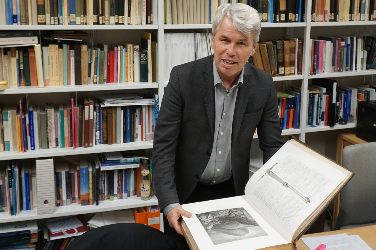 Konrad Schmid mit einer von Gustave Doré illustrierten Bibel aus dem 19. Jahrhundert. «Die Bibel schafft es auf einzigartige Weise, grundlegende Lebenserfahrungen zu verdichten», sagt der 60-jährige Theologe. Foto: sd