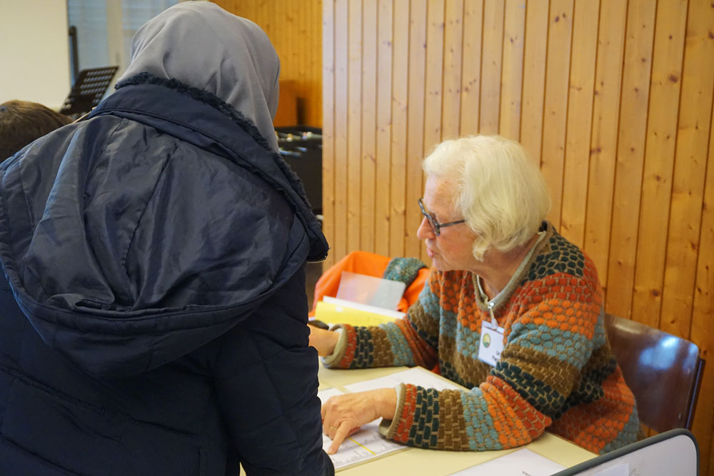 Ursi P. prüft die Ausweise und vergibt per Los die Nummern für die Reihenfolge der Lebensmittelausgabe. | Foto: Noemi Harnickell