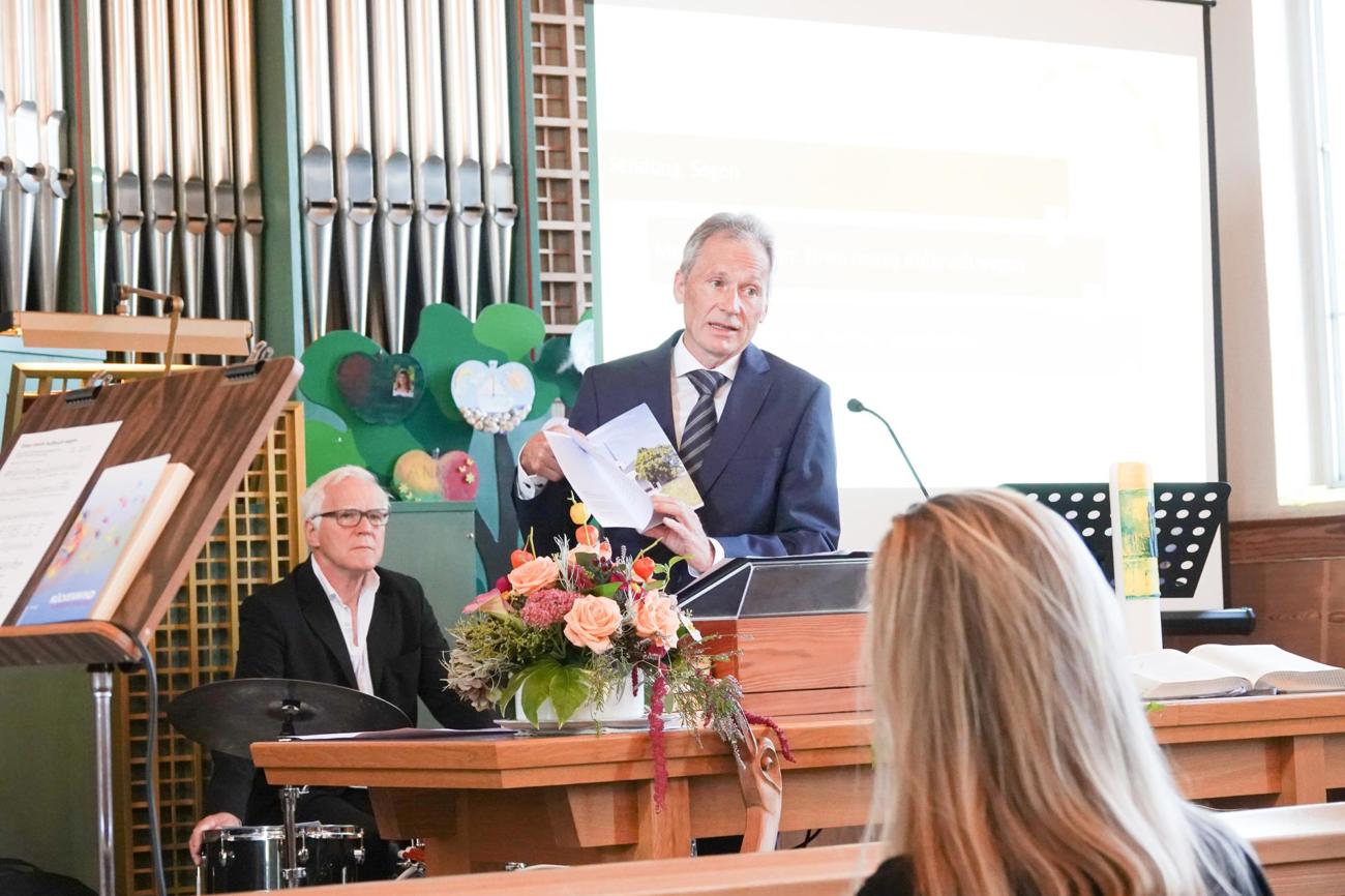 Kirchgemeindepräsident Michael Raduner übergibt die Festschrift der Öffentlichkeit. (Bild: zVg)